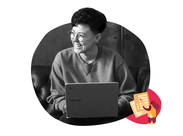 smiling person using a laptop in casual attire, modern workspace with creative elements and joyful atmosphere